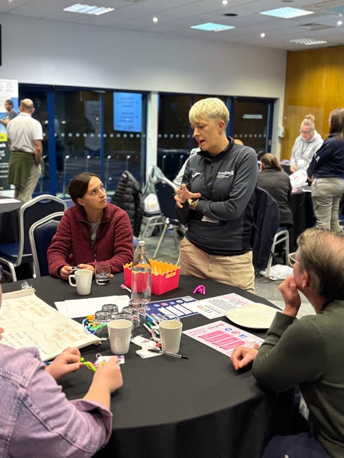 A photo of Leah Goode talking with people from local sports clubs who attended one of the two recent sport welfare events. 